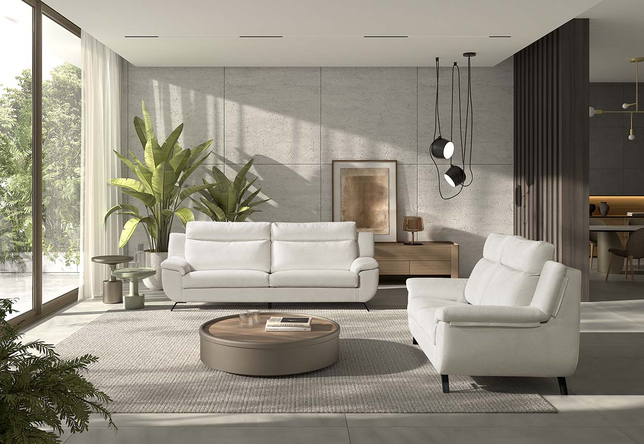 Sofá Vissuto Sinus blanco en salón moderno con paneles de madera, lámpara colgante y plantas tropicales