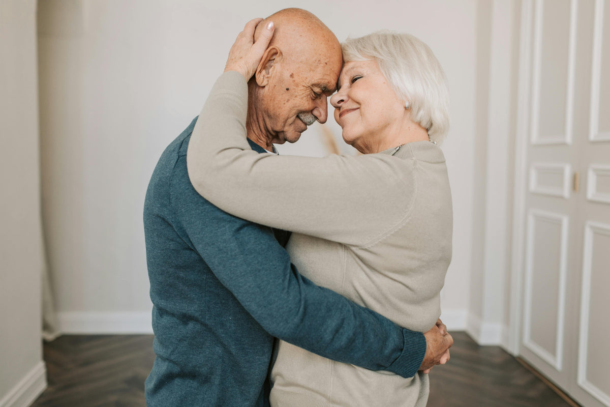 Pareja de personas mayores abranzándose con cama geriátrica Vissuto