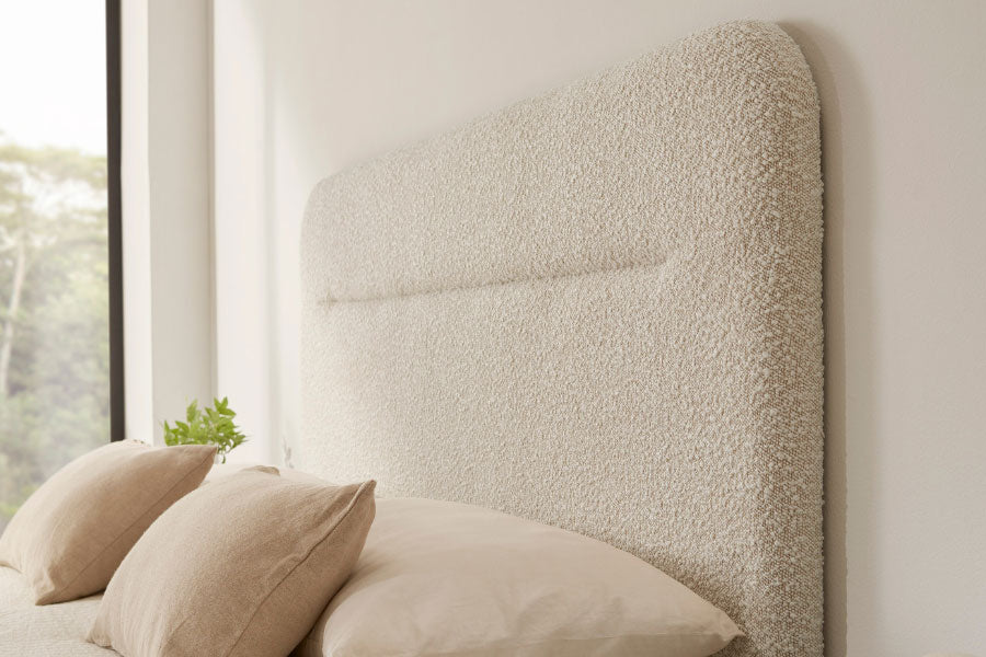 Detalle cabecero Moon Vissuto tapizado bouclé blanco roto con costura central y almohadas beige
