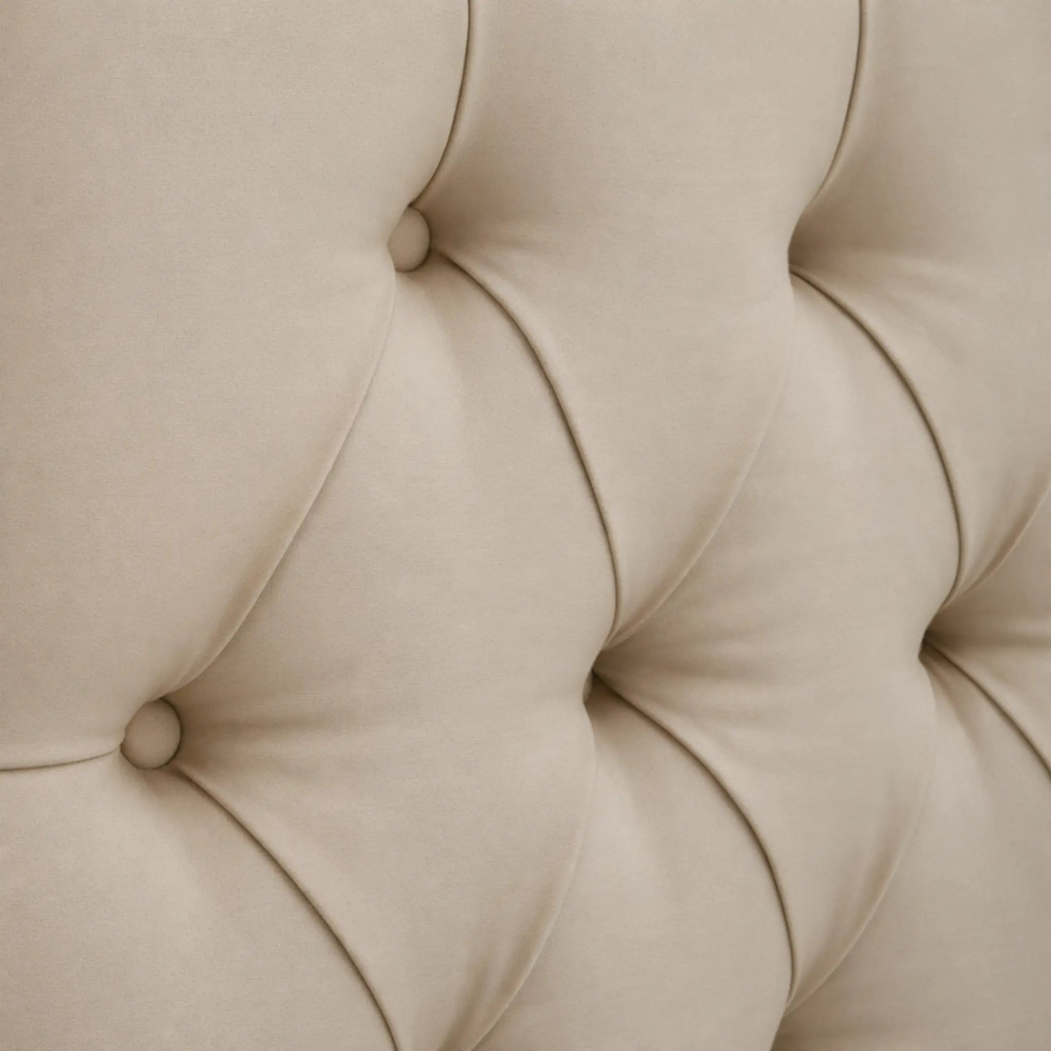 Cabecero capitoné rombos beige con botones forrados y costuras profundas.