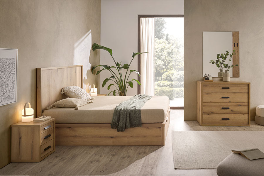 Imagen de canapé Vissuto comfort en dormitorio de madera con cojines, colcha verde, planta y ventanal con vistas a la naturaleza