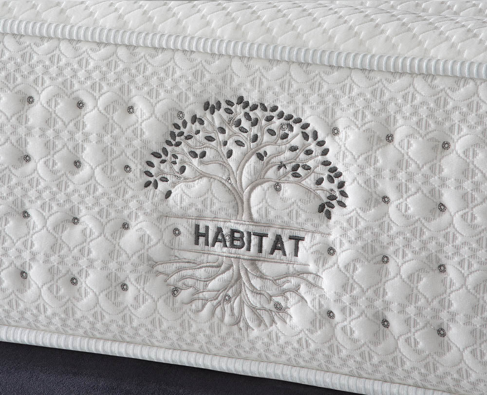 Imagen de detalle lateral arbol con la palabra HABITAT en el centro