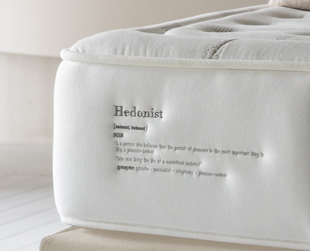 Lateral del colchón Vissuto Hedonist con la palabra Hedonist impresa y tejido acolchado blanco