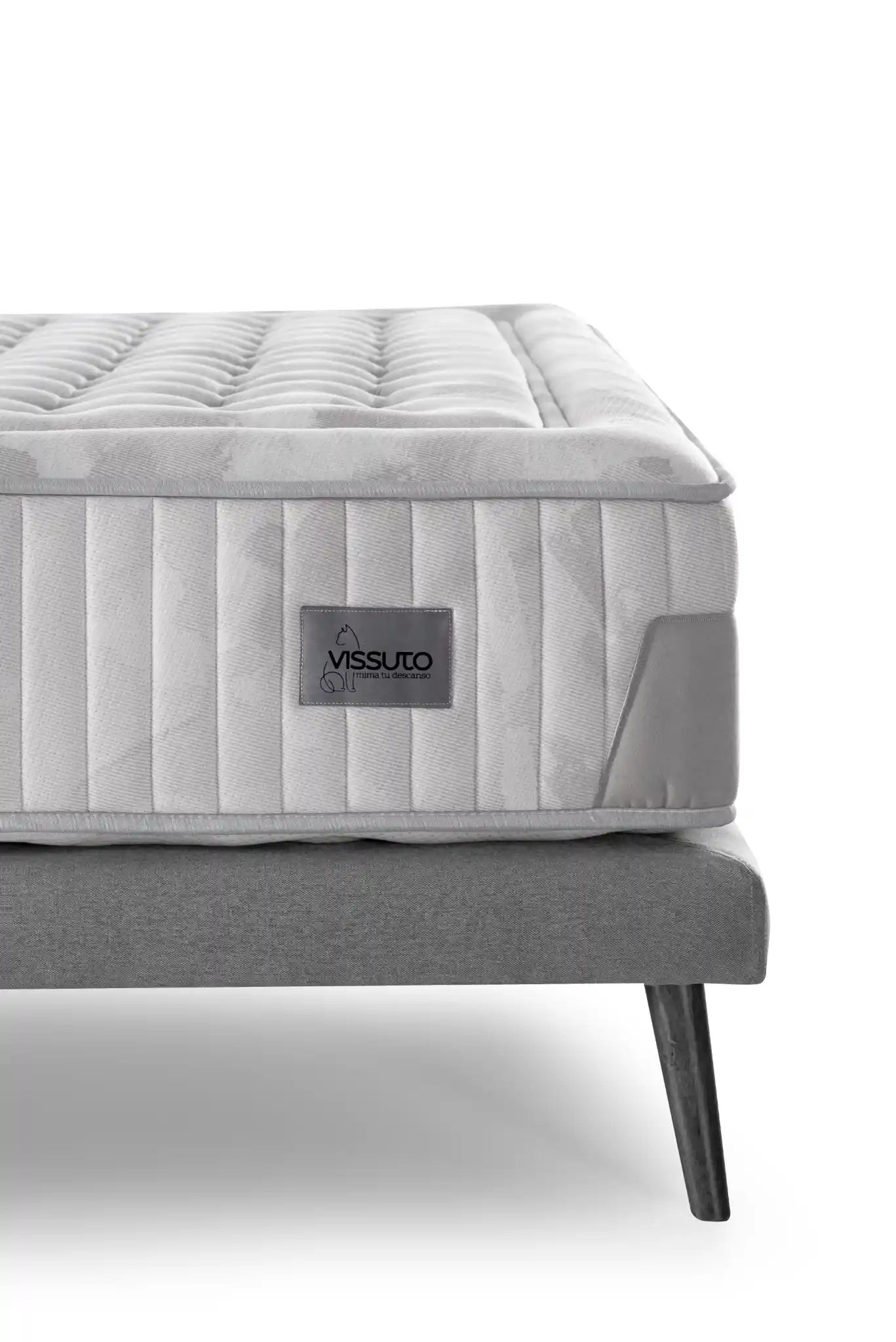 Detalle de colchón con marca VISSUTO sobre somier con patas