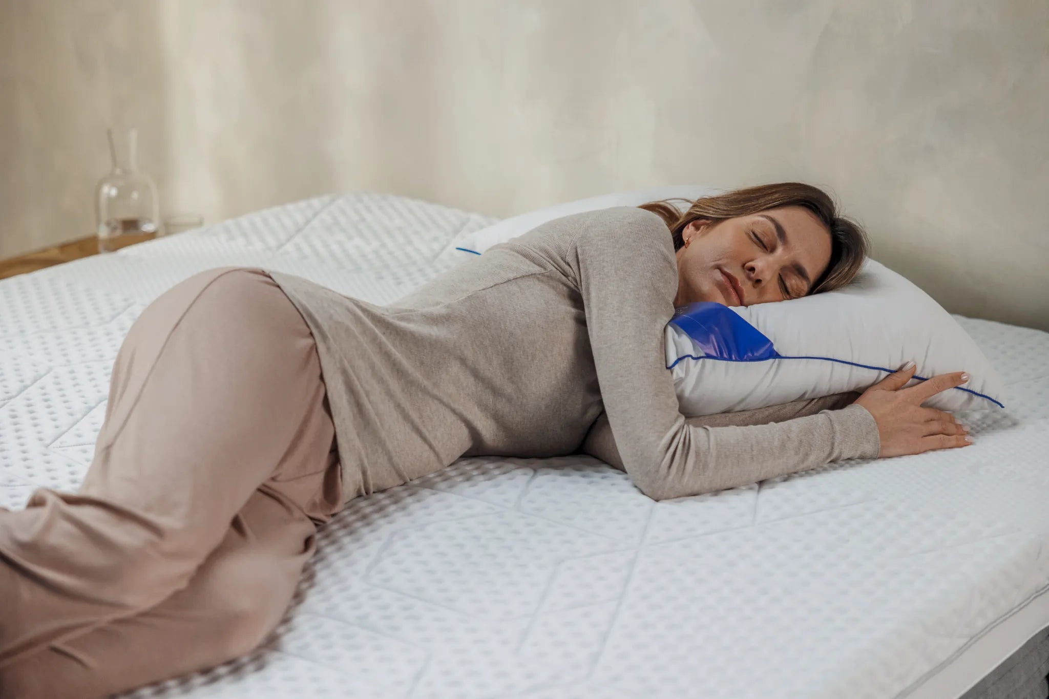 mujer tumbada en colchon abrazada a almohada
