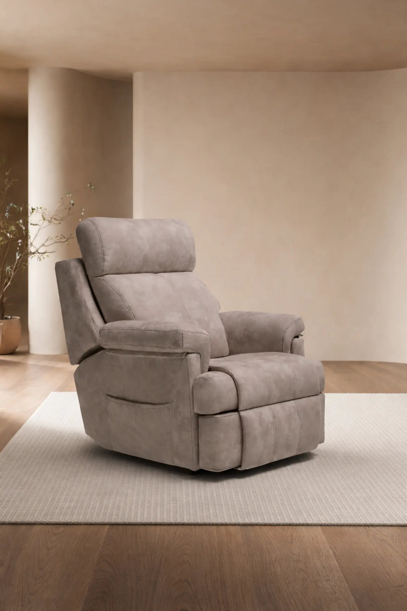 Sillón relax beige de terciopelo con brazos elevados ubicado en una sala minimalista, con pared curvada y piso y planta de madera.