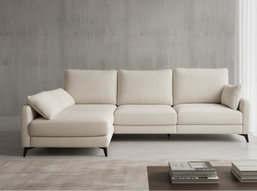 Chais longue color beige y patas de madera negras en salón acogedor con mesa y libros y paredes de madera en tono crema
